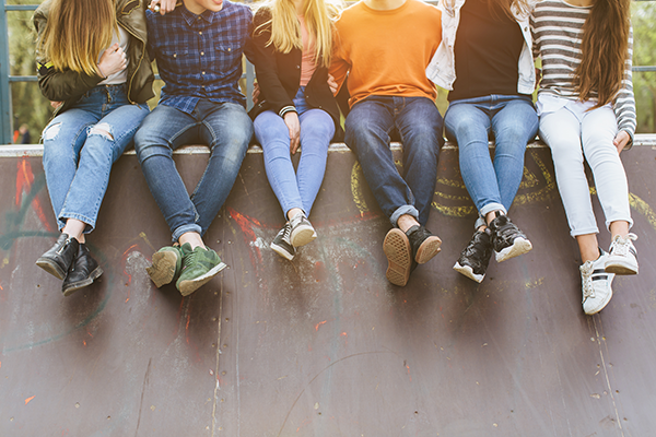 Group of young people sitting together in a relaxed social setting, representing the Kesgrave Hang Out youth sessions.